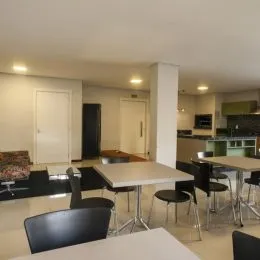 Sala de estar com mesa e cadeiras em ambiente interno.