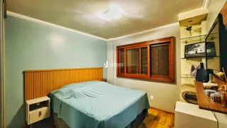 Quarto com cama e cabeceira de madeira.