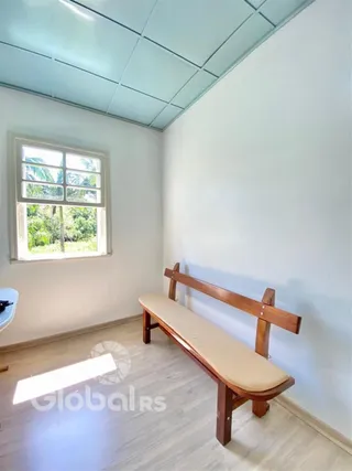 A sala apresenta uma janela com vista para a vegetação externa.