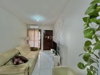 Sala de estar com sofá e piso de cerâmica clara.