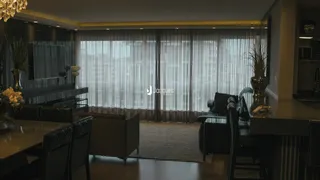 Sala de estar com grandes janelas e decoração escura.