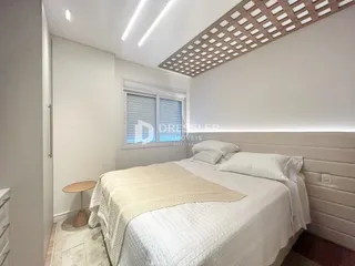 Quarto com cama de casal e paredes brancas em um imóvel.