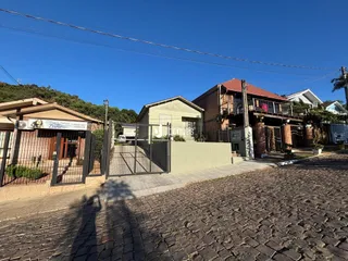 Vista da fachada de uma propriedade em Lajeado, Brasil, com cerca e portão de ferro.