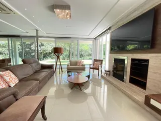 Sala de estar moderna com grandes janelas e área de estar bem iluminada.