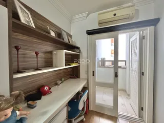 Interior de uma sala com estantes de madeira e porta de vidro.
