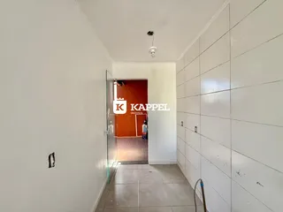 Foto de um corredor interno com paredes brancas e piso de cerâmica.