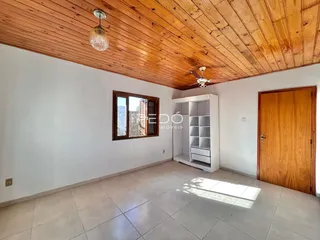 Sala de estar com teto de madeira e piso de cerâmica.