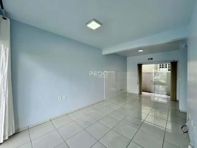 Imagem de um corredor interno com piso de cerâmica clara.
