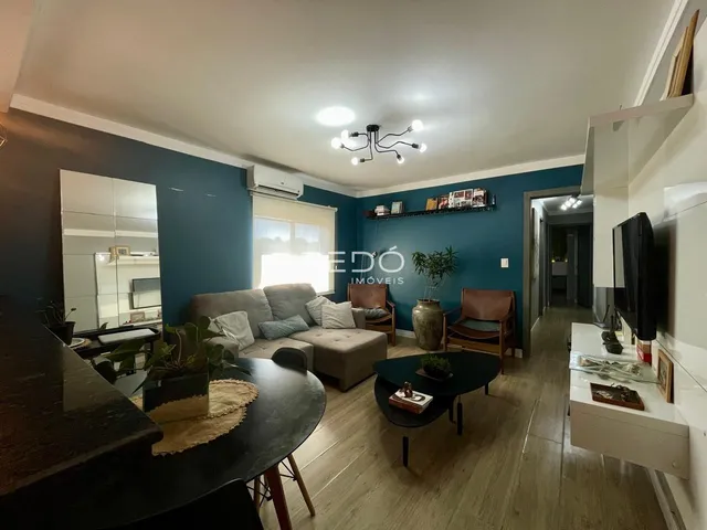 Sala de estar de um imóvel em Lajeado, Brasil, com piso de madeira clara e sofá.