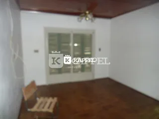 Foto interna de um cômodo com piso de madeira e uma janela.