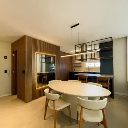 Foto de uma sala de jantar com mesa e cadeiras em um ambiente com painéis de madeira.