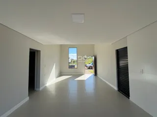 Vista de um corredor interno com paredes brancas e piso claro.