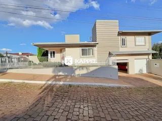 Fachada de uma residência em Lajeado, Brasil, com cerca e área frontal pavimentada.