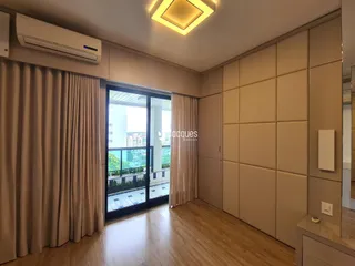 Sala de estar com piso de madeira e porta de vidro com vista.