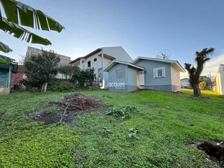 Vista externa de uma residência com jardim e vegetação em Lajeado.