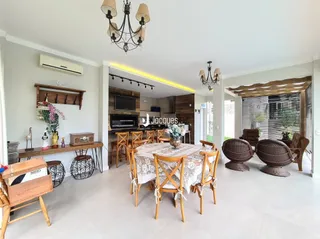 Sala de jantar com mesa de madeira e lustre.