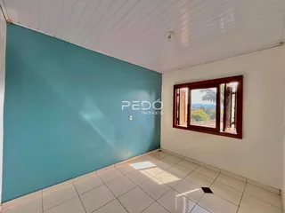 Parede azul em uma sala com piso de cerâmica e janela.