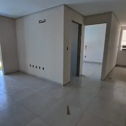 Vista interna de um ambiente com paredes brancas e piso claro.