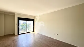 Ambiente interno com piso de madeira e porta de vidro.