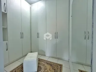 Hall com armários brancos e piso de cerâmica.
