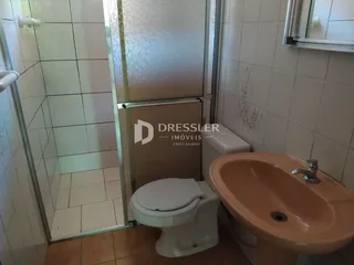 Foto de um banheiro com azulejos brancos e um box de vidro.