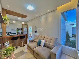 Sala de estar com sofá e vista para o exterior em um imóvel em Lajeado.