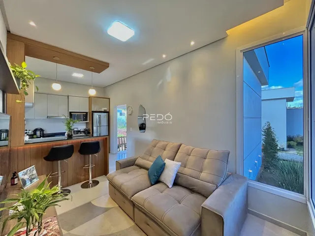 Sala de estar com sofá e vista para o exterior em um imóvel em Lajeado.