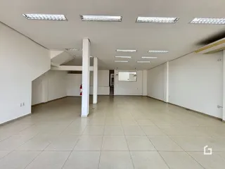 Espaço interno amplo com piso de cerâmica e paredes brancas.