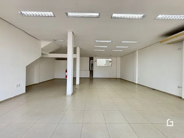 Espaço interno amplo com piso de cerâmica e paredes brancas.