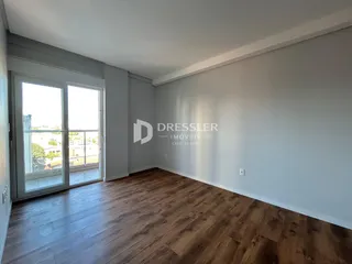 Sala de estar com piso de madeira e porta de vidro.