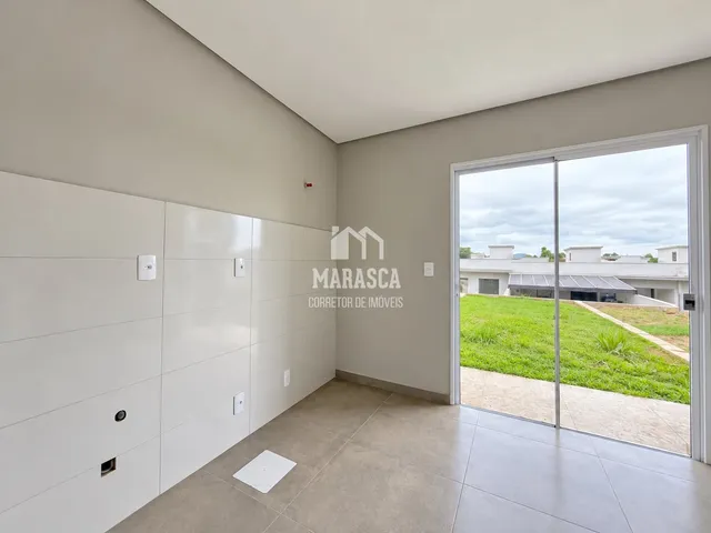 Ambiente interno de uma sala com porta de vidro abrindo para o exterior.