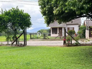Vista externa de uma casa com jardim e cerca em Lajeado.