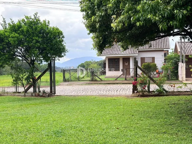 Vista externa de uma casa com jardim e cerca em Lajeado.
