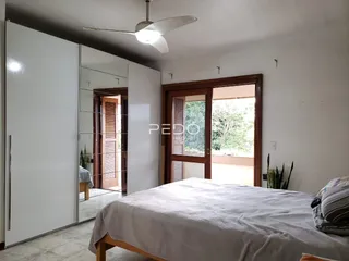 Quarto com cama e porta de madeira em um imóvel em Lajeado.