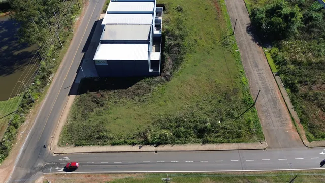 Vista aérea de um terreno com edifícios industriais e área gramada.