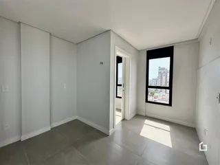 Interior de um ambiente com paredes brancas e piso de cerâmica.