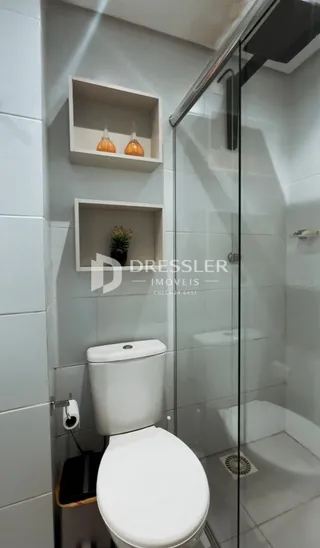 Foto de um banheiro com vaso sanitário e box de vidro.