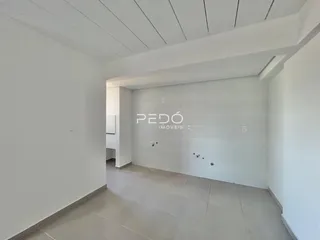 Hall de entrada com paredes brancas e piso claro.