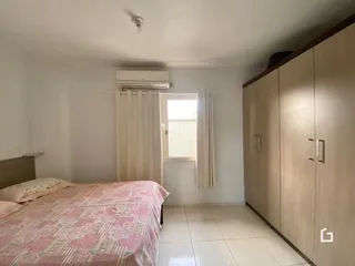 Quarto com cama e janela em ambiente claro.