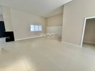 Vista interna de um ambiente com paredes brancas e piso claro.