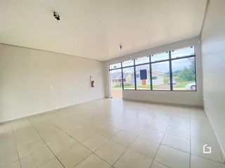 Uma sala ampla com piso de cerâmica e grande janela.