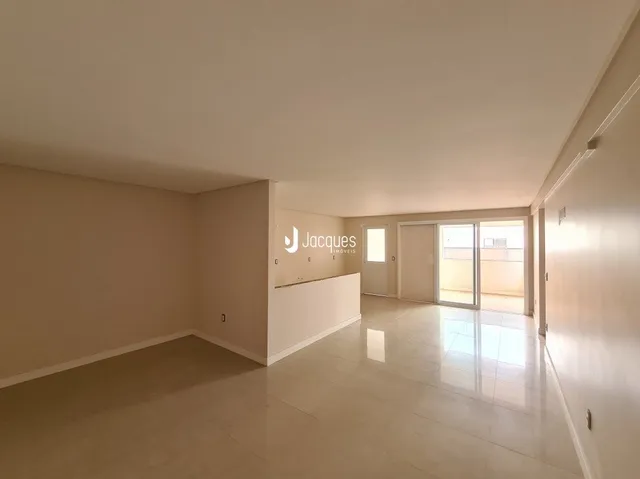 Interior de um espaço com paredes brancas e piso claro.