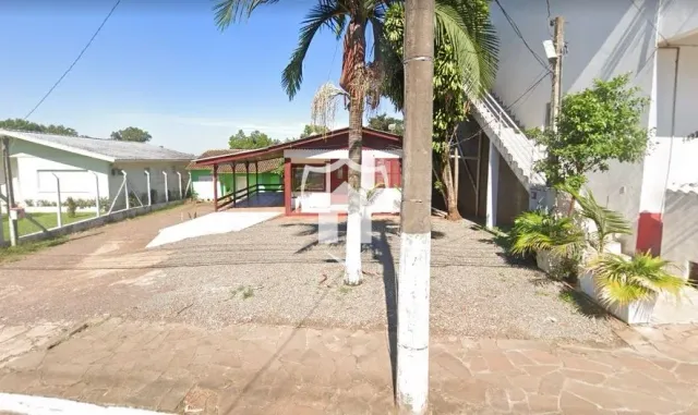 Vista externa de uma propriedade em Lajeado, Brasil, com estrutura de madeira e vegetação.