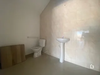 Foto de um ambiente interno com azulejos brancos e um vaso sanitário.