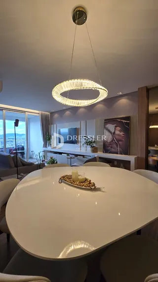 Vista de uma mesa de jantar moderna com lustre em um imóvel em Lajeado.