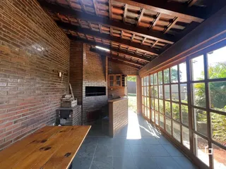 Interior de uma sala com paredes de tijolo aparente e grandes janelas.