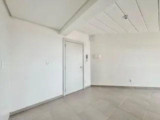 Foto de um ambiente interno com paredes brancas e piso de cerâmica.