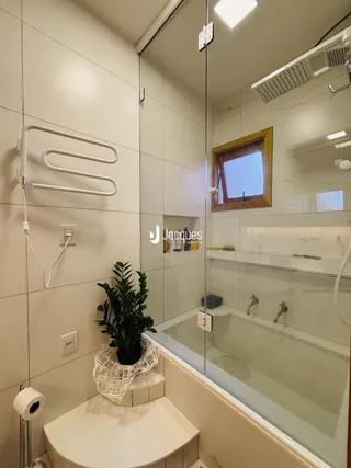 Foto de um banheiro com box de vidro e banheira em Lajeado.