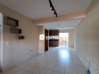 Um corredor interno com piso de cerâmica clara e prateleiras na parede.