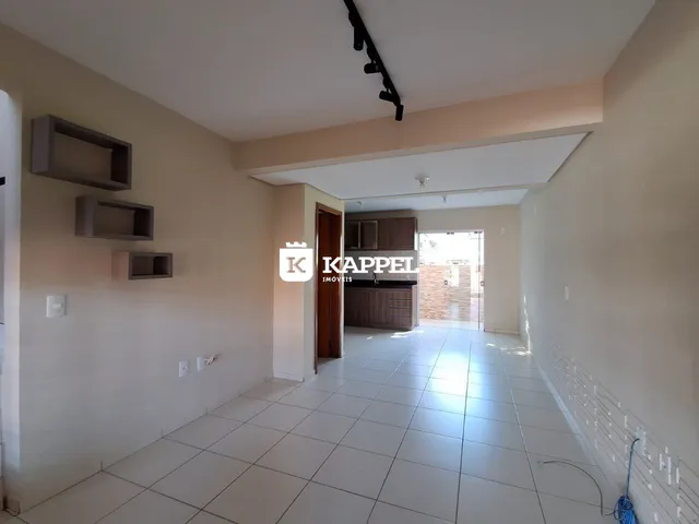 Um corredor interno com piso de cerâmica clara e prateleiras na parede.
